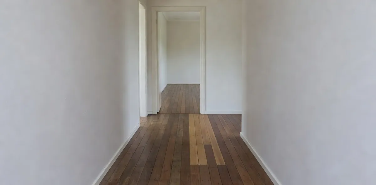 A hallway floor where lighter new boards have been let into an older darker hardwood floor